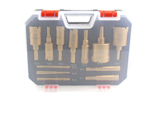 Twelve gold tile drills seen through the closed clear case lid.